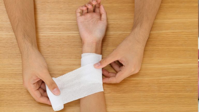 Healing skin on a forearm covered by a light dressing after a tattoo removal session