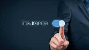A person in a business suit pressing a toggle switch labeled "insurance."