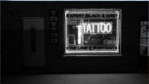 Black and white photo of the exterior of a tattoo parlor
