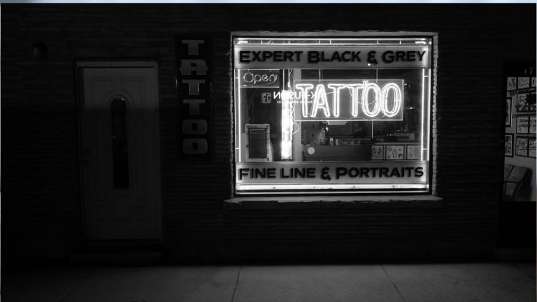 Black and white photo of the exterior of a tattoo parlor