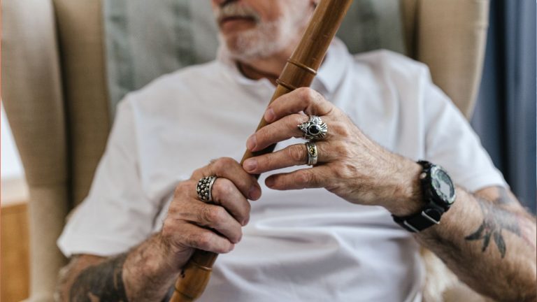 An elderly man with a decades-old tattoo on forearm